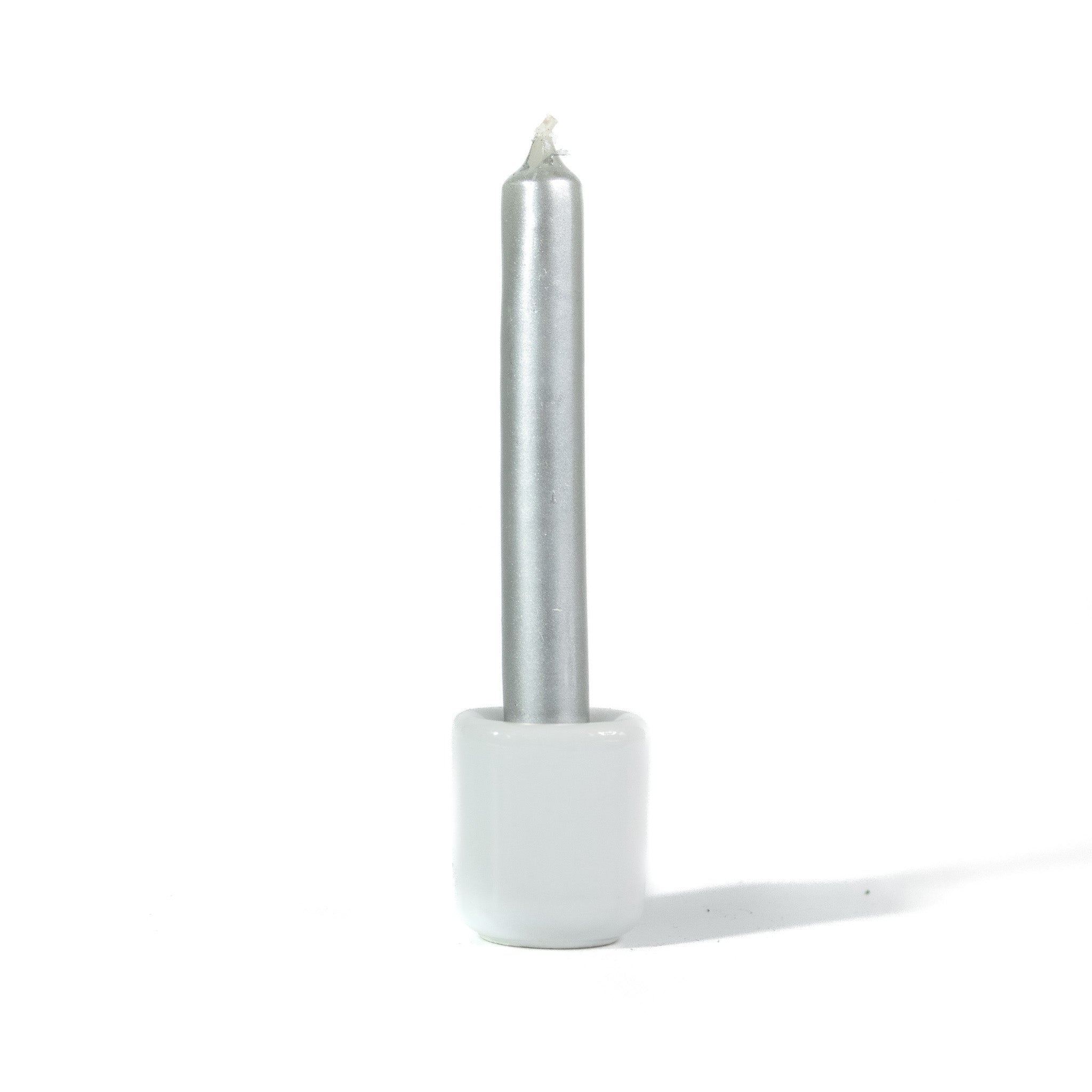 Small silver metallic chime spellwork candle in a white ceramic chime holder against a white background.