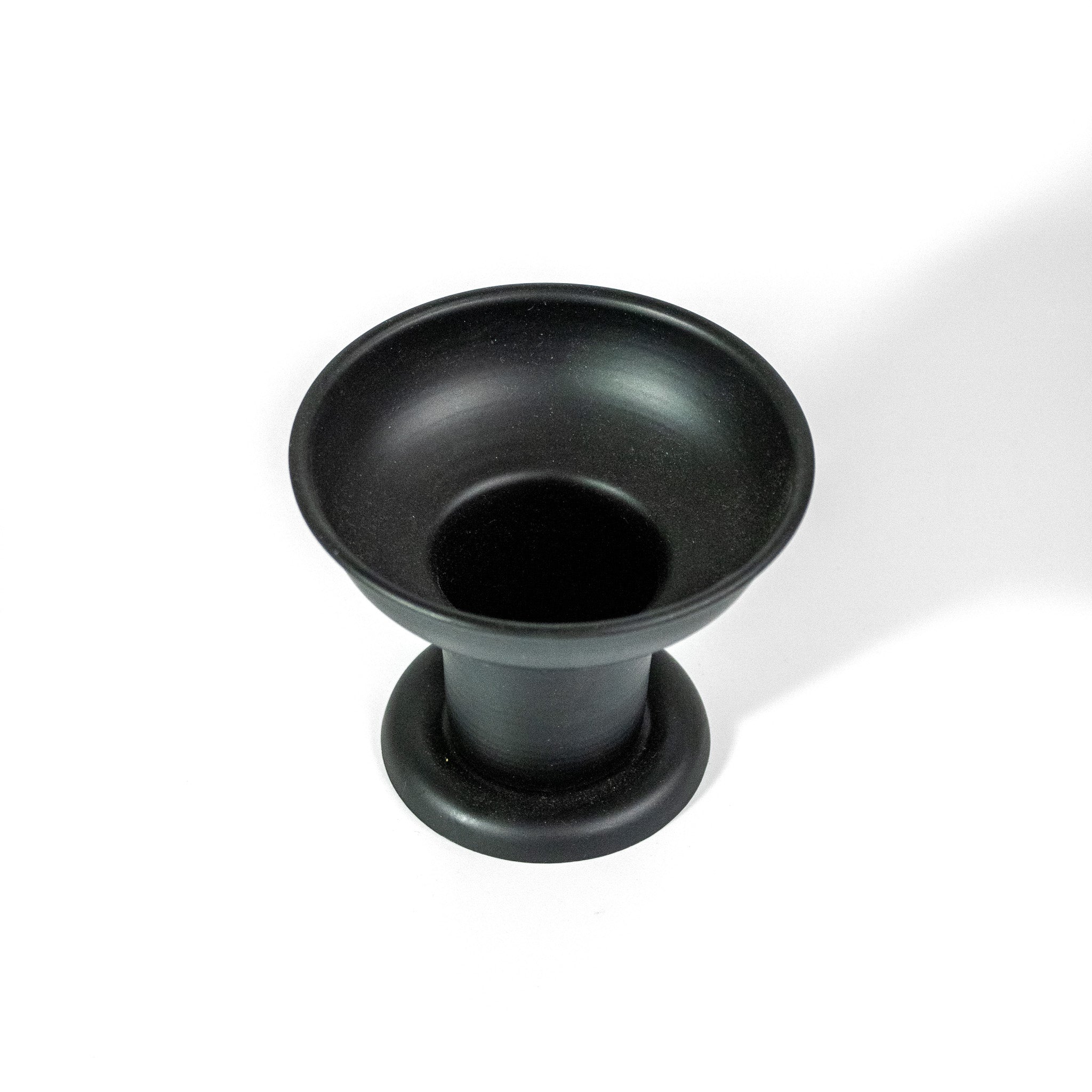 Black pillar candle holder looking down on it from the top showing the opening for the candle. 