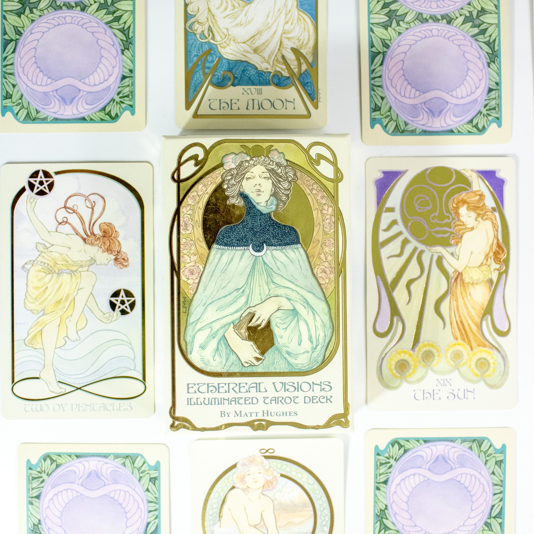 Ethereal Visions Tarot deck box. A woman dressed in blue holds a tattered book. Other cards are around the box.