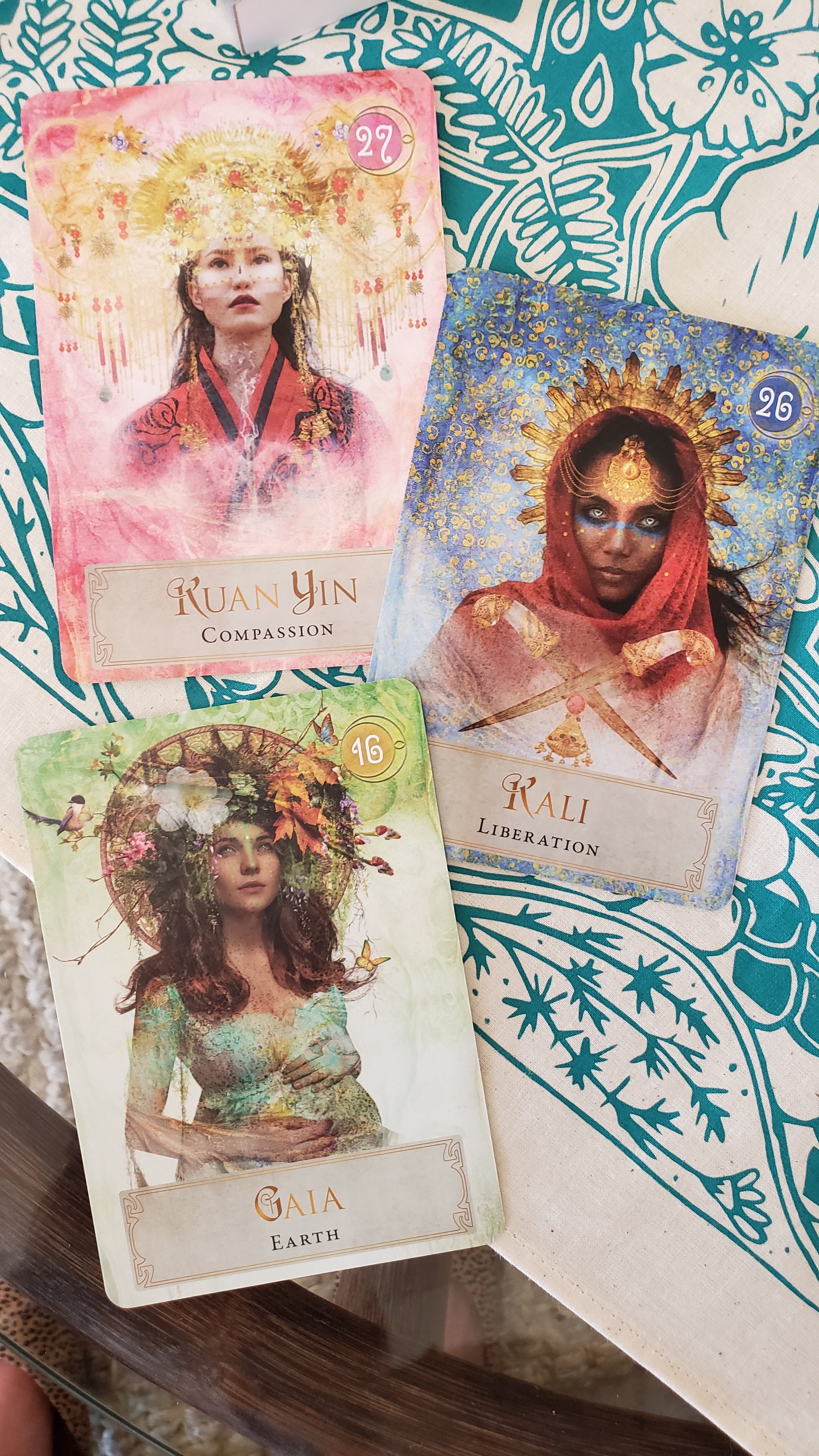 The Gaia, Kali and Kuan Yin Cards from the Goddess Power Oracle Deck are shown on a teal and beige altar cloth.